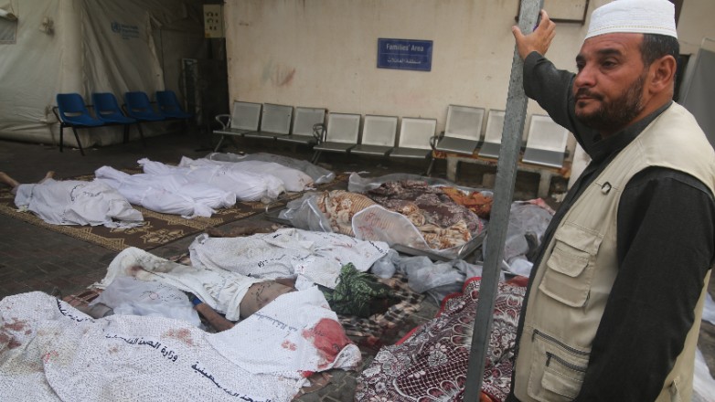 A Palestinian stands next to the bodies of people killed in the Israeli bombing of the Gaza Strip in Rafah on Tuesday, Oct. 24, 2023. (AP Photo/Hatem Ali)