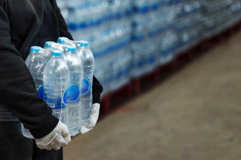 woman-carrying-drinking-waters-with-gloved-hands-during-coronavirus-pandemic