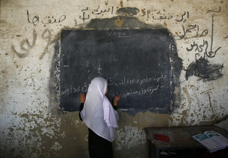 FILE - In this Sunday, Sept. 21, 2008 file photo, an Afghan girl writes on a board in front her class at the girls high school Ayeshe Sedeqa in the center of Kunduz, northern Afghanistan. The Afghan government alleges the Taliban tried to poison students at girls' schools, causing outbreaks of sickness, and says 15 suspects have been arrested. (AP Photo/Anja Niedringhaus, File)