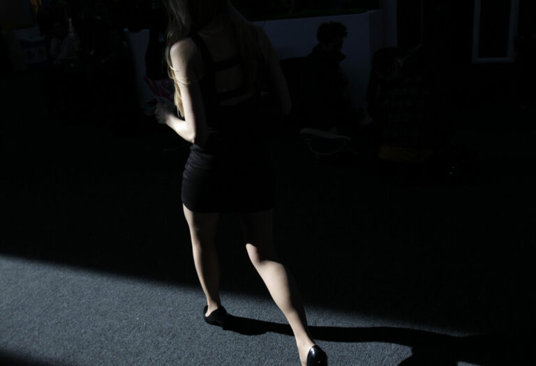 A Fashion Week attendee walk through the tents at Lincoln Center in New York, Thursday, Feb. 9, 2012.  (AP Photo/Seth Wenig)