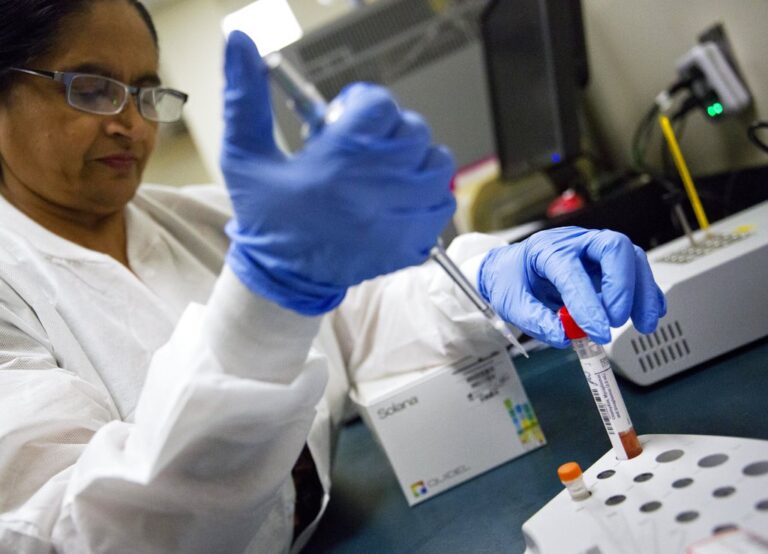 Lab technologist Sharda Modi tests a patient's swab for a flu infection at Upson Regional Medical Center in Thomaston, Ga., Friday, Feb. 9, 2018. The bad flu season has contributed to the rural hospital's 25 percent increase in emergency room patients from a year ago. A government report out Friday shows 1 of every 13 visits to the doctor last week was for fever, cough and other symptoms of the flu. That ties the highest level seen in the U.S. during swine flu in 2009. (AP Photo/David Goldman)