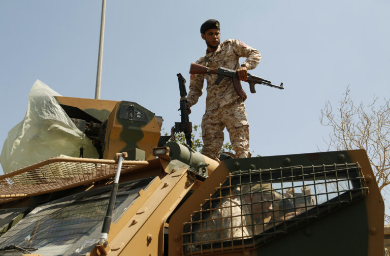 Libyan army forces and vehicles are stationed in a street in the country’s capital of Tripoli on Friday, July 22 2022. One of Libya’s rival governments on Friday called on militias to stop fighting, after clashes broke out in the country’s capital, Tripoli overnight, killing at least one civilian and forcing around 200 people to flee the area. (AP Photo/Yousef Murad)