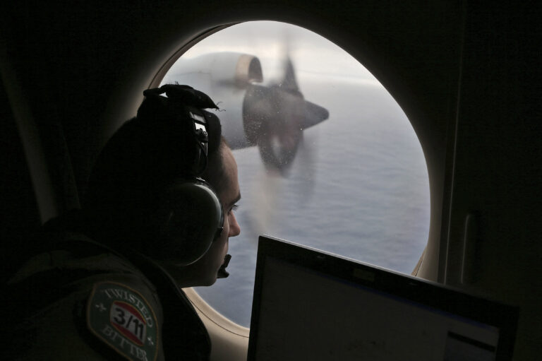 FILE - Flight officer Rayan Gharazeddine scans the water in the southern Indian Ocean off Australia from a Royal Australian Air Force AP-3C Orion during a search for the missing Malaysia Airlines Flight MH370 on March 22, 2014. A decade ago this week, a Malaysia Airlines flight vanished without a trace to become one of aviation’s biggest mystery. Investigators still do not know exactly what happened to the plane and its 239 passengers. (AP Photo/Rob Griffith, File)