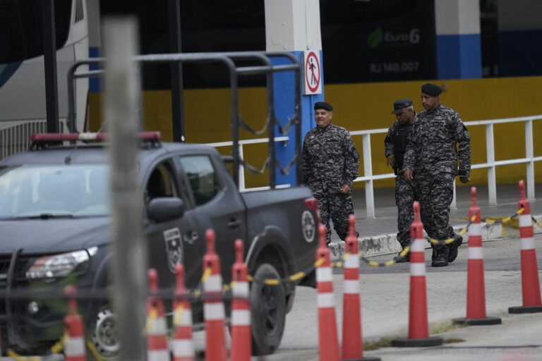 Elite police walk through a bus terminal where police say a gunman wounded two people and took 17 others hostage aboard a bus, in Rio de Janeiro, Brazil, Tuesday, March 12, 2024.  (AP Photo/Silvia Izquierdo)