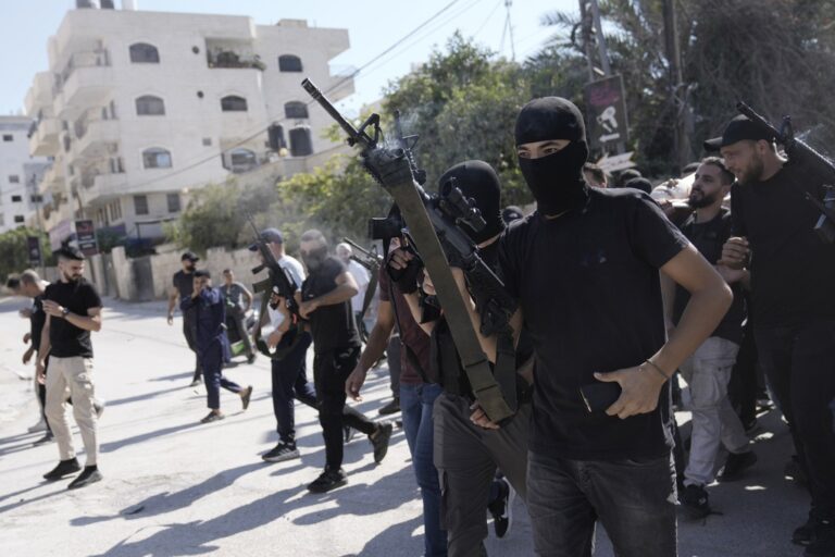 Gunmen attend the funeral of five Palestinians killed by an Israeli strike on a vehicle in the West Bank city of Jenin, Tuesday, Aug. 6, 2024.  (AP Photo/Majdi Mohammed)