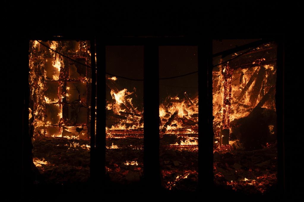 A house burns in Varnava village during a wildfire, north of Athens, Greece, Sunday, Aug. 11, 2024. Many regions of the country are on high alert due to high temperatures and winds. (AP Photo/Michael Varaklas)