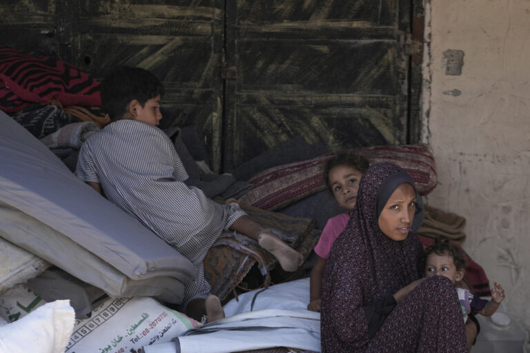 Palestinians wait to evacuate a school that had been their shelter, in eastern Deir al-Balah, Gaza Strip, Friday, Aug. 16, 2024, after the Israeli military dropped leaflets asking civilians to evacuate from the area, saying forces plan to respond to rocket fire that targeted Israel. (AP Photo/Abdel Kareem Hana)