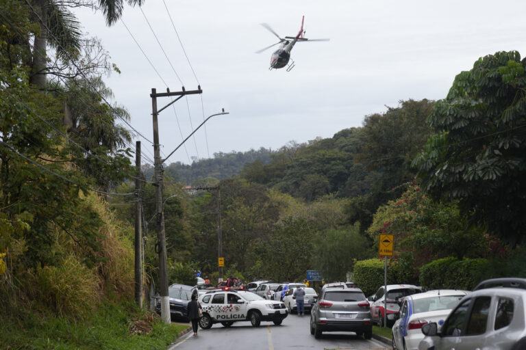 Police patrol the street leading to the gated community where a plane crashed in Vinhedo, Sao Paulo state, Brazil, Friday, Aug. 9, 2024. (AP Photo/Andre Penner)