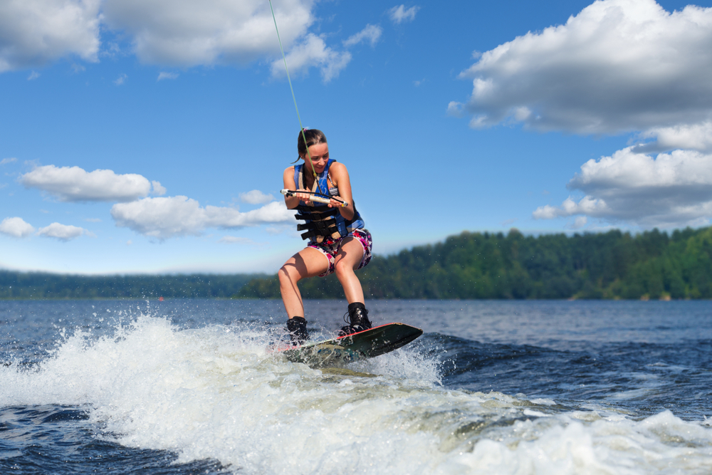 Young,Pretty,Slim,Brunette,Woman,Riding,Wakeboard,On,Wave,Of