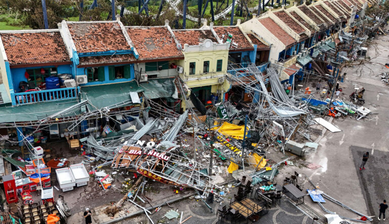 (FILES) This aerial picture shows damaged buildings and debris on a street after Super Typhoon Yagi hit Ha Long, in Quang Ninh province, on September 8, 2024. Factory roofs blown off, products worth millions of dollars destroyed, supply chains disrupted: Typhoon Yagi has had a disastrous impact on local and global companies in northern Vietnam who could take months to recover, business leaders warn. (Photo by Nhac NGUYEN / AFP) / To go with 'VIETNAM-TYPHOON-FLOOD-ECONOMY-CLIMATE, FOCUS' by Alice PHILIPSON