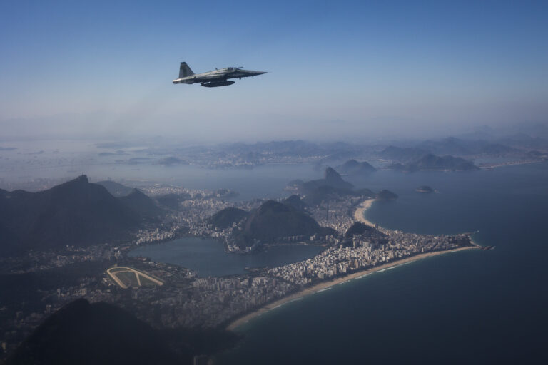 A F-5 fighter flies over Rio de Janeiro while intercepting another aircraft, photographed through a window, during a Brazilian Air Force presentation for the press ahead of the Olympic games in Rio de Janeiro, Brazil, Thursday, July 14, 2016. (AP Photo/Felipe Dana)