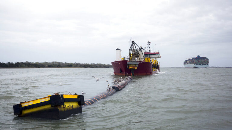 In this photo provided by the Georgia Port Authority, the container ship COSCO Glory, with a capacity of 13,100 twenty-foot equivalent container units, passes the dredge Padre Island as it works the Savannah Harbor entrance channel, Wednesday, Feb. 28, 2018, in Tybee Island, Ga. The U.S. Army Corps of Engineers marked the completion of outer harbor dredging at the Port of Savannah Wednesday, as it reached the midpoint of the Savannah Harbor Expansion Project. (Stephen Morton/Georgia Port Authority via AP)