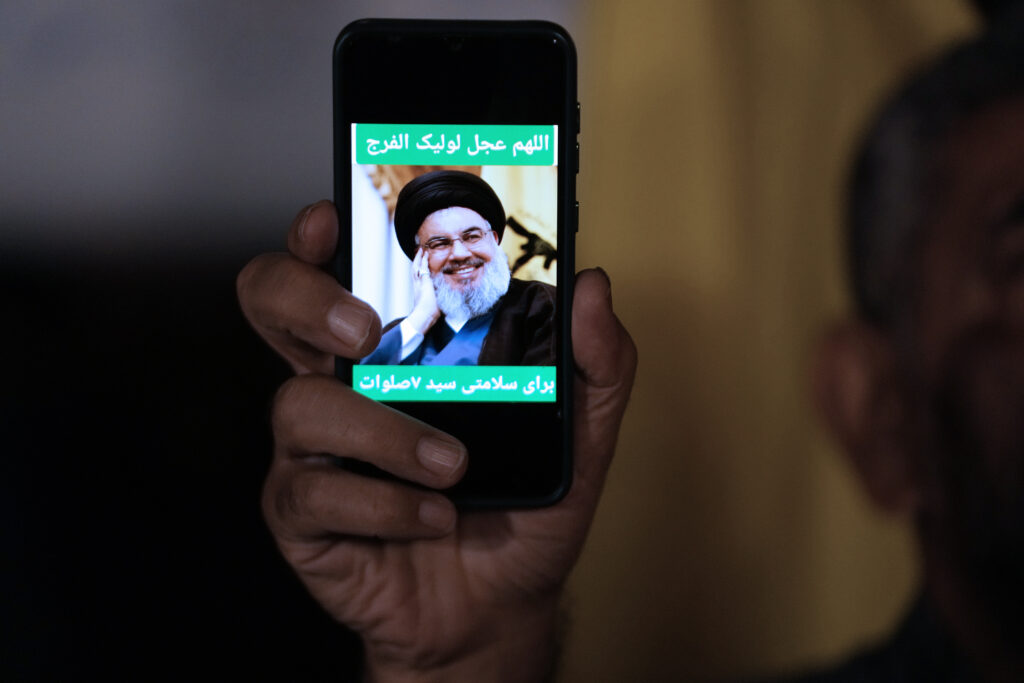 An Iranian demonstrator shows a portrait of Hezbollah leader Hassan Nasrallah on his cell phone in support of Hezbollah at the Felestin (Palestine) Square in downtown Tehran, Iran, early Saturday, Sept. 28, 2024. (AP Photo/Vahid Salemi)