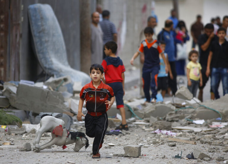 A Palestinian child runs on debris from a destroyed house, following an overnight Israeli strike in Beit Lahiya, in northern Gaza strip, Saturday, July 19, 2014. A Gaza health official says the death toll from Israel's 12-day offensive against Hamas militants has topped 300. (AP Photo/Lefteris Pitarakis)