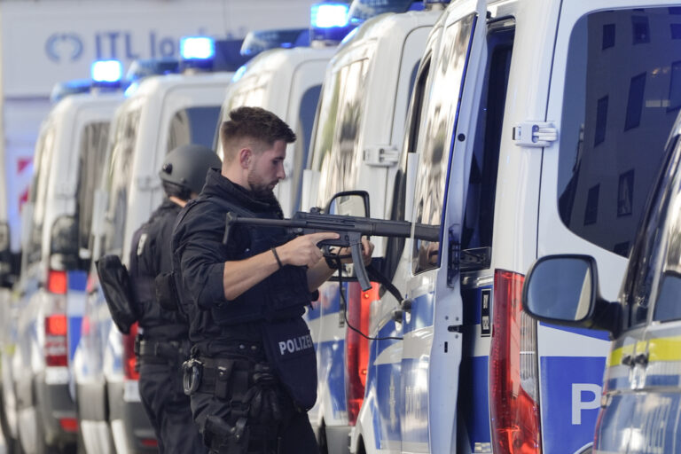 Police officers stand next to their cars after police fired shots at a suspicious person near the Israeli Consulate and a museum on the city's Nazi-era history in Munich, Germany, Thursday, Sept. 5, 2024. (AP Photo/Matthias Schrader)