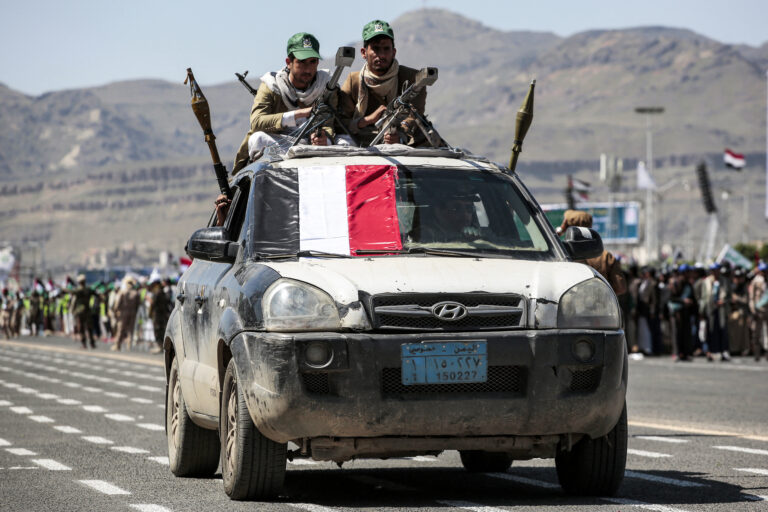 Fighters loyal to Yemen's Huthi sit with heavy machine guns atop a vehicle with other fighters inside carrying rocket-propelled grenade launchers (RPG)during a military parade marking the anniversary of the Huthis' 2014 takeover of the capital Sanaa and in solidarity with the Palestinian people, in Sanaa on September 21, 2024. (Photo by Osama ABDULRAHMAN / AFP)