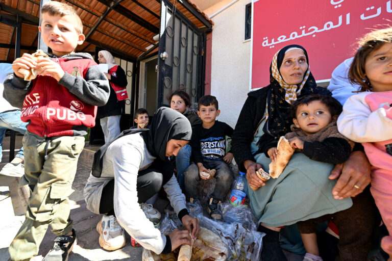 Displaced Syrians and Lebanese sit down to rest after entering Syria from Lebanon via the Jusiyeh border crossing with Quseir in Syria's central Homs province on October 2, 2024. Lebanon said on October 2 that almost 240,000 people, mostly Syrians, have crossed to Syria since Israel began pounding the country last week with intense air strikes on what it says are Hezbollah targets. (Photo by LOUAI BESHARA / AFP)