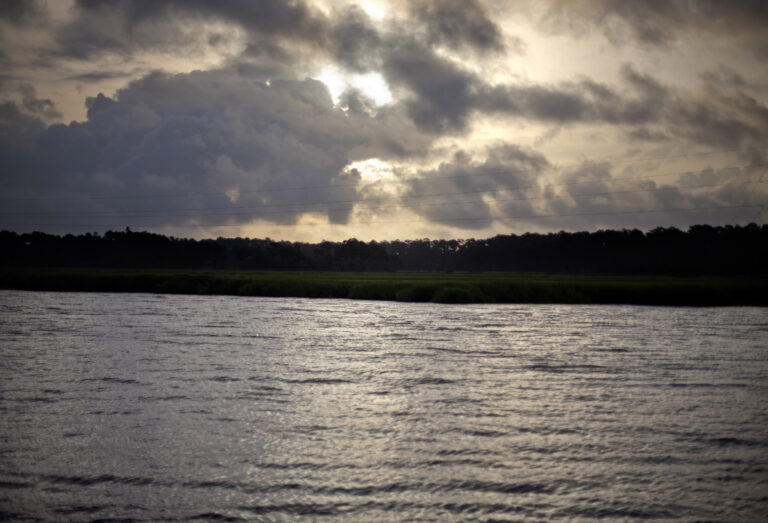 FILE -  In this June 10, 2013, file photo, the sun rises over Sapelo Island, Ga. Residents and property owners in one of the few remaining Gullah-Geechee communities of slave descendants on the Southeast coast are suing a variety of state and county agencies, accusing them of discrimination and neglect. The lawsuit alleges landowners on Sapelo Island pay high property taxes while receiving few basic services from surrounding McIntosh County or the state of Georgia. (AP Photo/David Goldman, File)