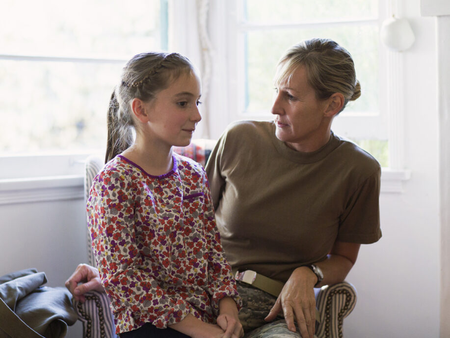 Military mom at home having a serious conversation with daughter.