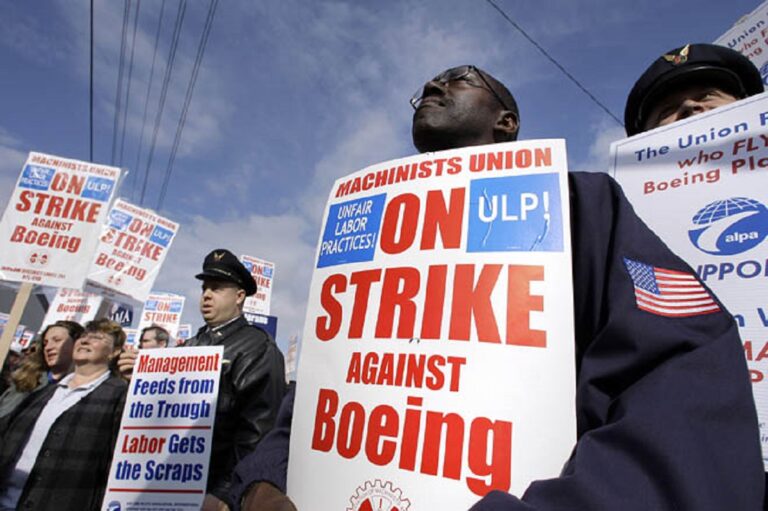 Boeing Co. machinists and supporters look on during a rally Thursday, Oct. 9, 2008, outside a Boeing administration  building in Seattle. The day hasn't been announced, but Boeing and the striking Machinists union have agreed to resume negotiations in hope of ending the strike, now over a month old The union is demanding better job security, Boeing says it needs flexibility. The strike has idled 27,000 workers, mostly in the Puget Sound region and also in Portland and Wichita. (AP Photo/Elaine Thompson)