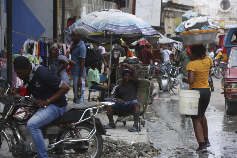 A man rests on a wheelbarrow on a street in Port-au-Prince, Haiti, Monday, Sept. 23, 2024. (AP Photo/Odelyn Joseph)