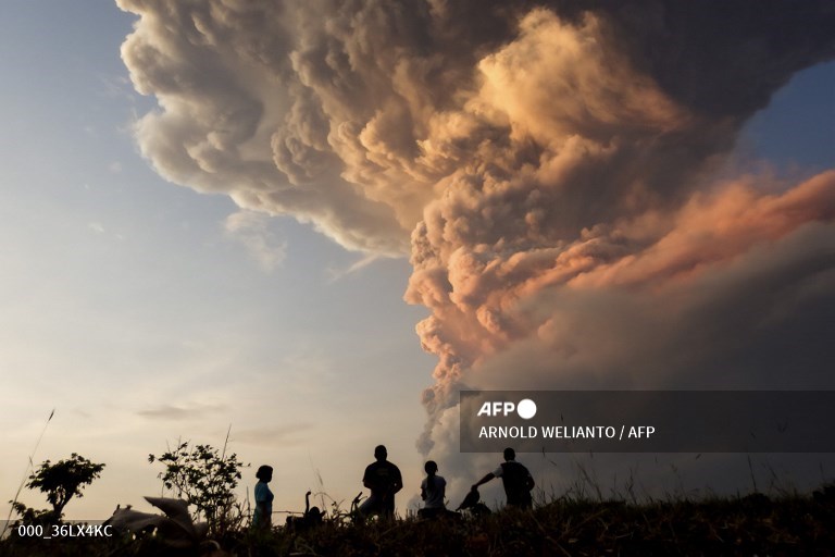 Residents watch the eruption of Mount Lewotobi Laki Laki from Lewolaga village in East Flores, East Nusa Tenggara on November 9, 2024. (Photo by ARNOLD WELIANTO / AFP)