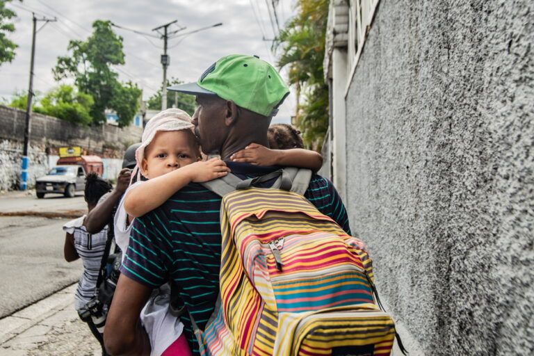 epa11315128 A man with his son carries his belongings after an attack of illegal armed gangs in the sector Delmas 22 in Port-Au-Prince, Haiti, 02 May 2024. The government of Haiti extends for three days the curfew in the East department of Port-Au-Prince which is dominated for illegal armed gangs that impose terror among the citizens.  EPA/Mentor David Lorens