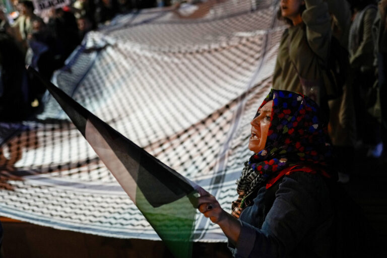 A woman holds a Palestinian flag as she shouts slogans with others during a pro-Palestinians rally in Istanbul, Turkey, Tuesday, Oct. 15, 2024. (AP Photo/Francisco Seco)