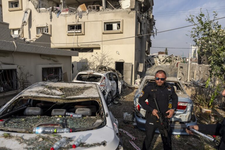 Israeli police men work at the site where projectiles fired from Lebanon hit a home in Tira, central Israel, Saturday, Nov. 2, 2024. (AP Photo/Ariel Schalit)