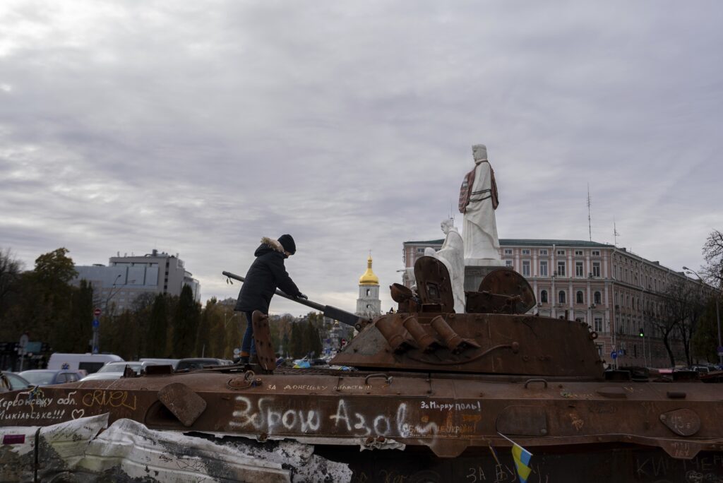 A boy stands on Russian burned APC in central Kyiv, Ukraine, Tuesday, Nov. 5, 2024. (AP Photo/Alex Babenko)