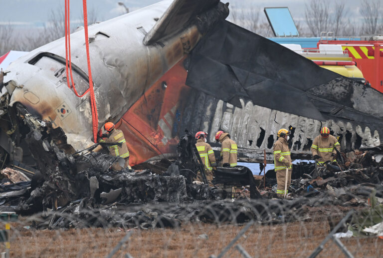 Firefighters and recovery teams work at the scene where a Jeju Air Boeing 737-800 series aircraft crashed and burst into flames at Muan International Airport in Muan, some 288 kilometres southwest of Seoul on December 30, 2024. The Boeing 737-800 was carrying 181 people from Thailand to South Korea when it crashed on arrival on December 29, killing everyone aboard -- save two flight attendants pulled from the twisted wreckage of the worst aviation disaster on South Korean soil. (Photo by JUNG YEON-JE / AFP)