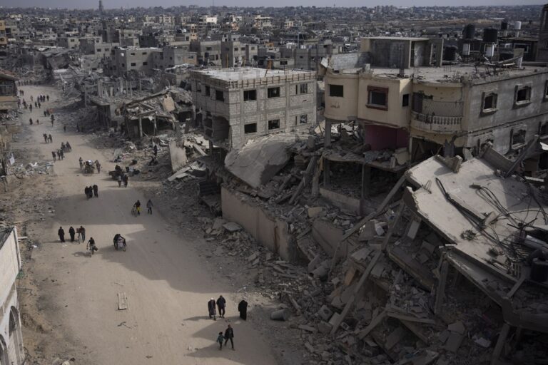 FILE - Palestinians walk through the destruction in the wake of an Israeli air and ground offensive in Khan Younis, southern Gaza Strip, Monday, April 8, 2024. (AP Photo/Fatima Shbair, File)