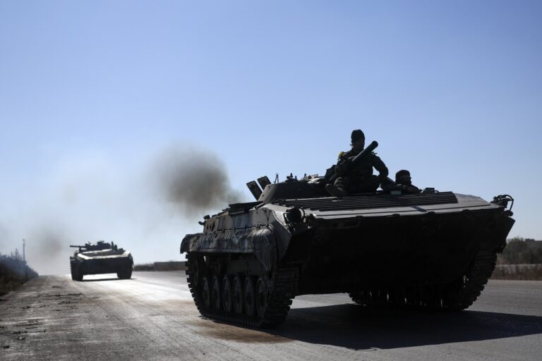 Syrian opposition fighters drive a seized seized Syrian army armoured vehicle near the town of Khan Assubul, Syria, southwest of Aleppo, Sunday, Dec. 1, 2024. Syrian opposition insurgency launched a campaign on Wednesday with a two-pronged attack on Aleppo and the countryside around Idlib.(AP Photo/Ghaith Alsayed)