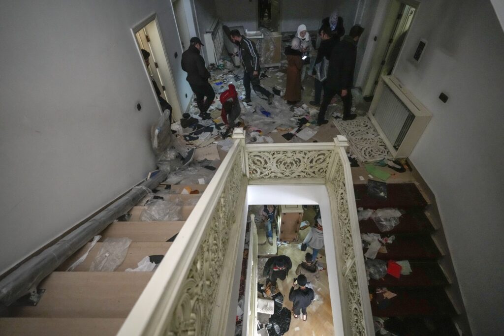 People search for belongings in the ransacked private residence of Syrian President Bashar Assad in the Malkeh district of Damascus, Syria, on Sunday, Dec. 8, 2024. (AP Photo/Hussein Malla)