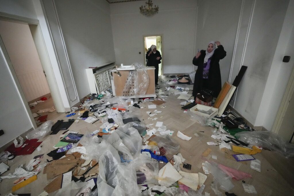 A woman looks at a ransacked room at the private residence of Syrian President Bashar Assad in the Malkeh district of Damascus, Syria, on Sunday, Dec. 8, 2024. (AP Photo/Hussein Malla)