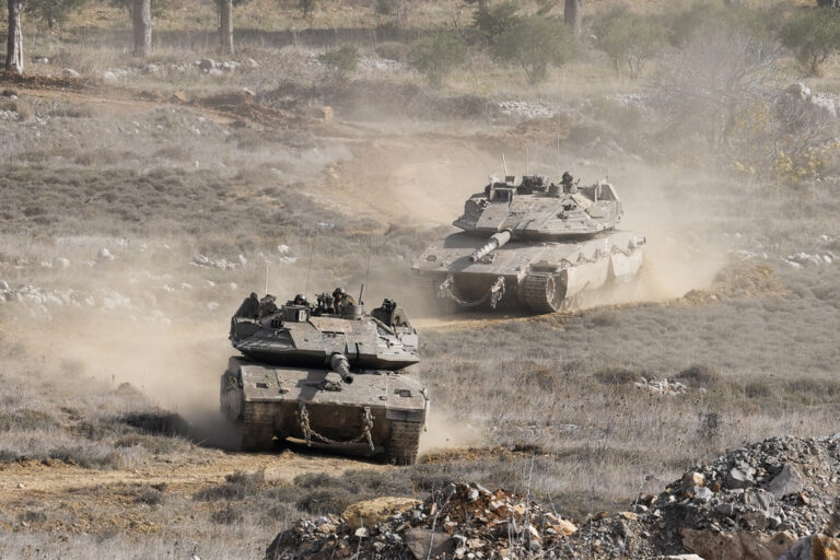 Israeli tanks maneuver next to the security fence near the so-called Alpha Line that separates the Israeli-annexed Golan Heights from Syria, in the town of Majdal Shams, Wednesday, Dec. 11, 2024. (AP Photo/Matias Delacroix)