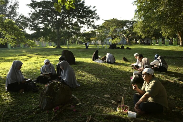 People pray at a mass grave of victims of the 2004 Indian Ocean tsunami in Banda Aceh, Indonesia, Thursday, Dec. 26, 2024. (AP Photo/Reza Saifullah)