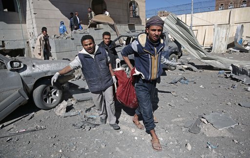 People carry the body of a man they uncovered from under the rubble of a Houthi-held detention center destroyed by Saudi-led airstrikes in Sanaa, Yemen, Wednesday, Dec. 13, 2017. (AP Photo/Hani Mohammed)