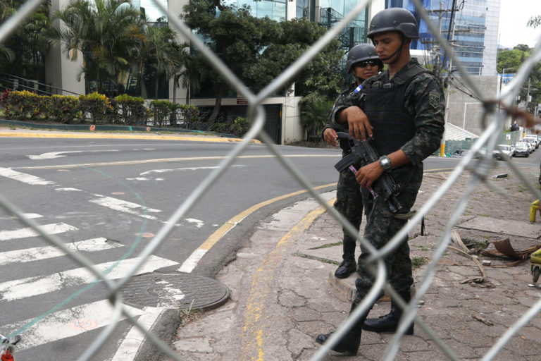 Army soldiers stand guard near the Presidential palace, after a night of rioting in Tegucigalpa, Honduras, Thursday, June 20, 2019. Protesters blockaded highways, clashed with police and ransacked stores in Honduras as part of demonstrations against President Juan Orlando Hernández. (AP Photo/Elmer Martinez)