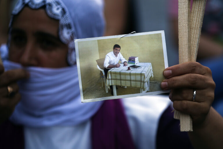 A supporter of pro-Kurdish People's Democratic Party (HDP), holds a picture of the party's former co-leader Selahattin Demirtas, currently in Turkish prison on charges of leading a terror organisation, as she participates in a rally in Istanbul, Thursday, June 18, 2020. Members of the party are traveling to the capital Ankara from the southeastern and northwestern corners of the country to protest an on-going government crackdown on the political movement that officials accuse of links to Kurdish militants. (AP Photo/Emrah Gurel)