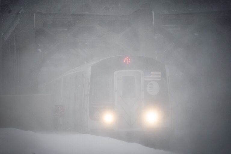 The headlights of a New York City subway peeks through a snowstorm as it arrives at a station. Monday, Feb. 1, 2021, in Brooklyn, New York. (AP Photo/Wong Maye-E)