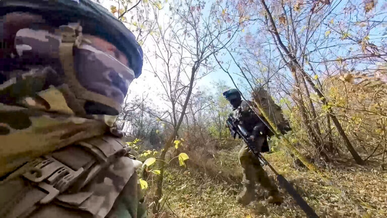 In this photo taken from video released by the Russian Defense Ministry Press Service on Tuesday, Nov. 26, 2024, a couple of Russian Army snipers walk changing their position while fighting with Ukrainian Armed forces at an undisclosed location in Ukraine. (Russian Defense Ministry Press Service via AP)