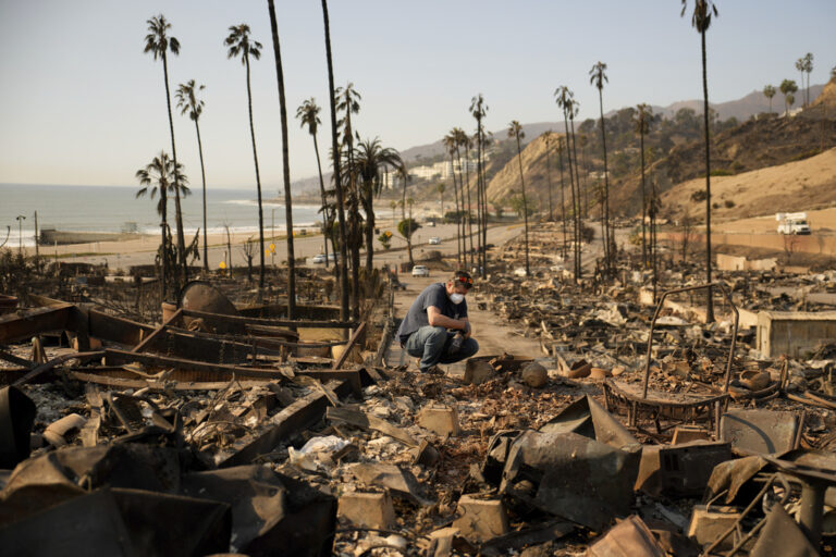 Kevin Marshall sifts through his mother's fire-ravaged property in the the Palisades Fire in the Pacific Palisades neighborhood of Los Angeles, Saturday, Jan. 11, 2025. (AP Photo/John Locher)