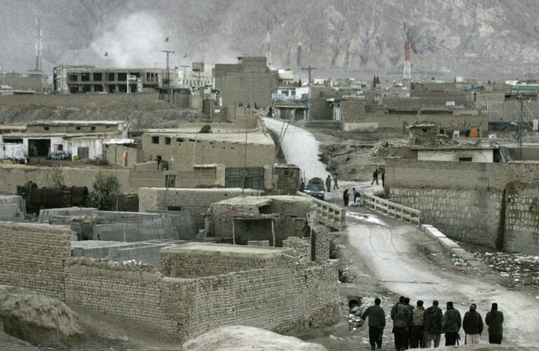 Pakistani security forces take positions in a street leading to the site of a bomb blast, top left, in Quetta, Pakistan, Saturday, Feb. 16, 2013. A bomb ripped through a crowded vegetable market in a mostly Shiite neighborhood in a southern Pakistani city Saturday, killing scores of people in a horrific attack on the country's minority Muslim sect. (AP Photo/Arshad Butt)