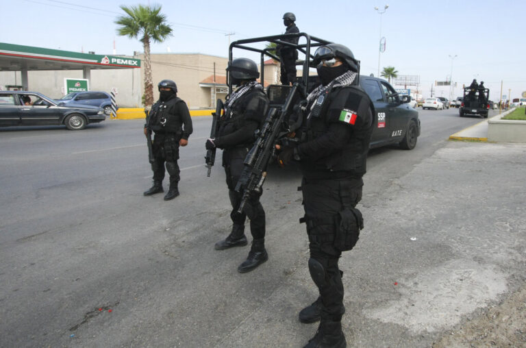 Rapid response Coahuila state police stand at a checkpoint in the city of Piedras Negras, Mexico, Tuesday, Sept. 18, 2012. Federal police units and Mexican troops, including 70 members of an elite military special forces unit, are searching for inmates who fled the prison in this city across the border from Eagle Pass, Texas. They escaped allegedly through a tunnel 21 feet long and 4 feet in diameter on on Monday Sept. 17 and then cut their way through a chain link barrier and escaped onto a neighboring property. (AP Photo/Adriana Alvarado)