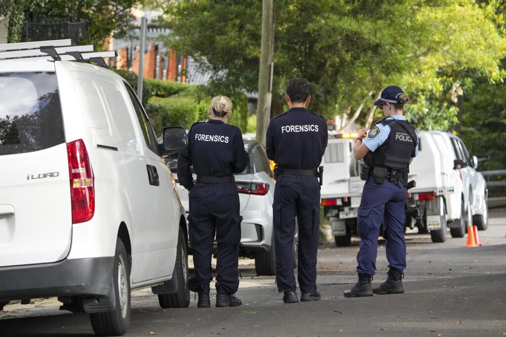 Police stand near houses vandalized with anti-Israel slogans in the Sydney suburb of Woollahra, Australia, Wednesday, Dec. 11, 2024. (AP Photo/Mark Baker)