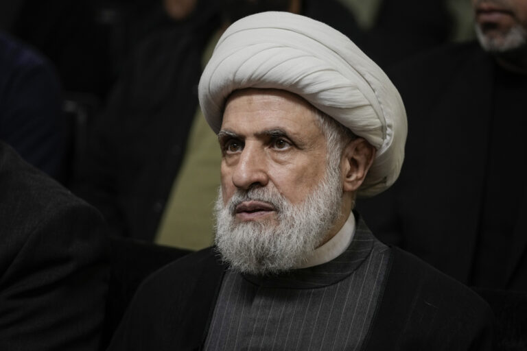 FILE - Hezbollah's deputy leader, Sheikh Naim Kassem, listens to a speech by then-leader Hassan Nasrallah on a screen in southern Beirut, Wednesday, June 19, 2024. (AP Photo/Bilal Hussein, File)