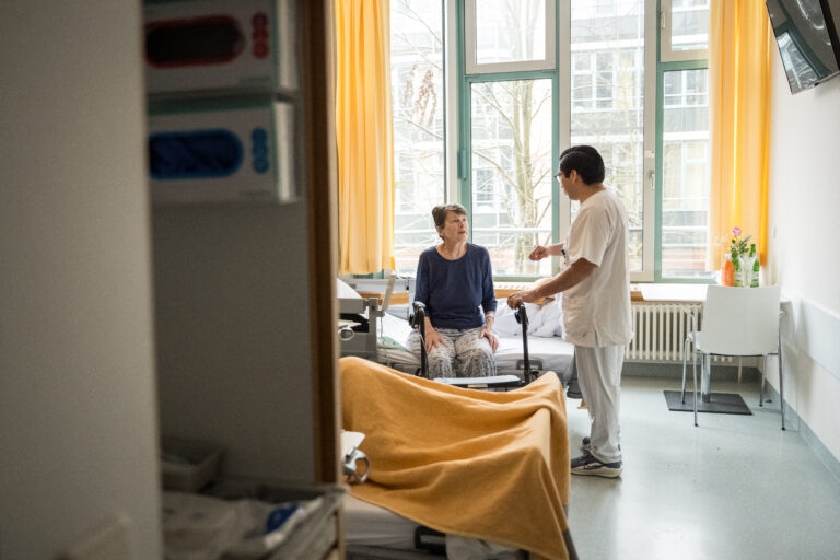 Nursing professional Lorenzo Santiago Fernandez Yam from Mexico attends to patient Sibylle Hasenbein at the hospital (BG Klinikum Unfallkrankenhaus Berlin) on February 13, 2025 in Berlin. National elections on February 23, 2025 are expected to deliver victory for the conservative CDU/CSU bloc and a strong second-place showing for the far-right Alternative for Germany (AfD). Both parties have promised a crackdown on immigration, with the AfD campaigning in parts of the country with fake plane tickets to send illegal migrants on a one-way journey home. Hospital managers are "worried" that tensions over immigration will make it harder for Germany to recruit enough skilled workers from abroad to fill a growing labour shortage. (Photo by STEFANIE LOOS / AFP)