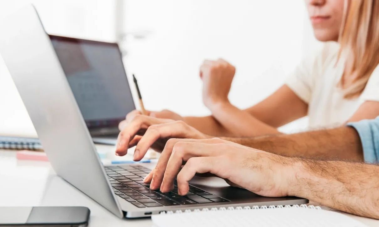 008bf7b2-crop-hands-typing-laptop-workplace