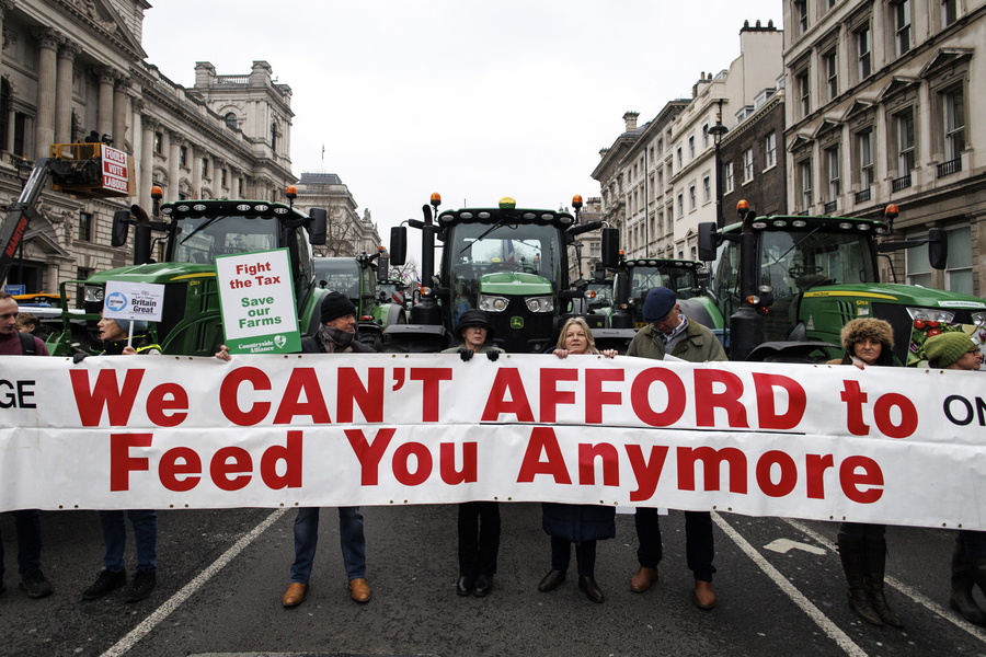 epa11886577 British farmers hold a banner as they gridlock Whitehall with their tractors during a protest over changes to inheritance tax (IHT) rules, in London, Britain, 10 February 2025. British farmers demand a reversal of the changes to inheritance tax rules announced in the October 2024 budget by the Labour government, which will introduce new taxes on farms worth more than 1 million GBP that would apply from April 2026.  EPA/TOLGA AKMEN